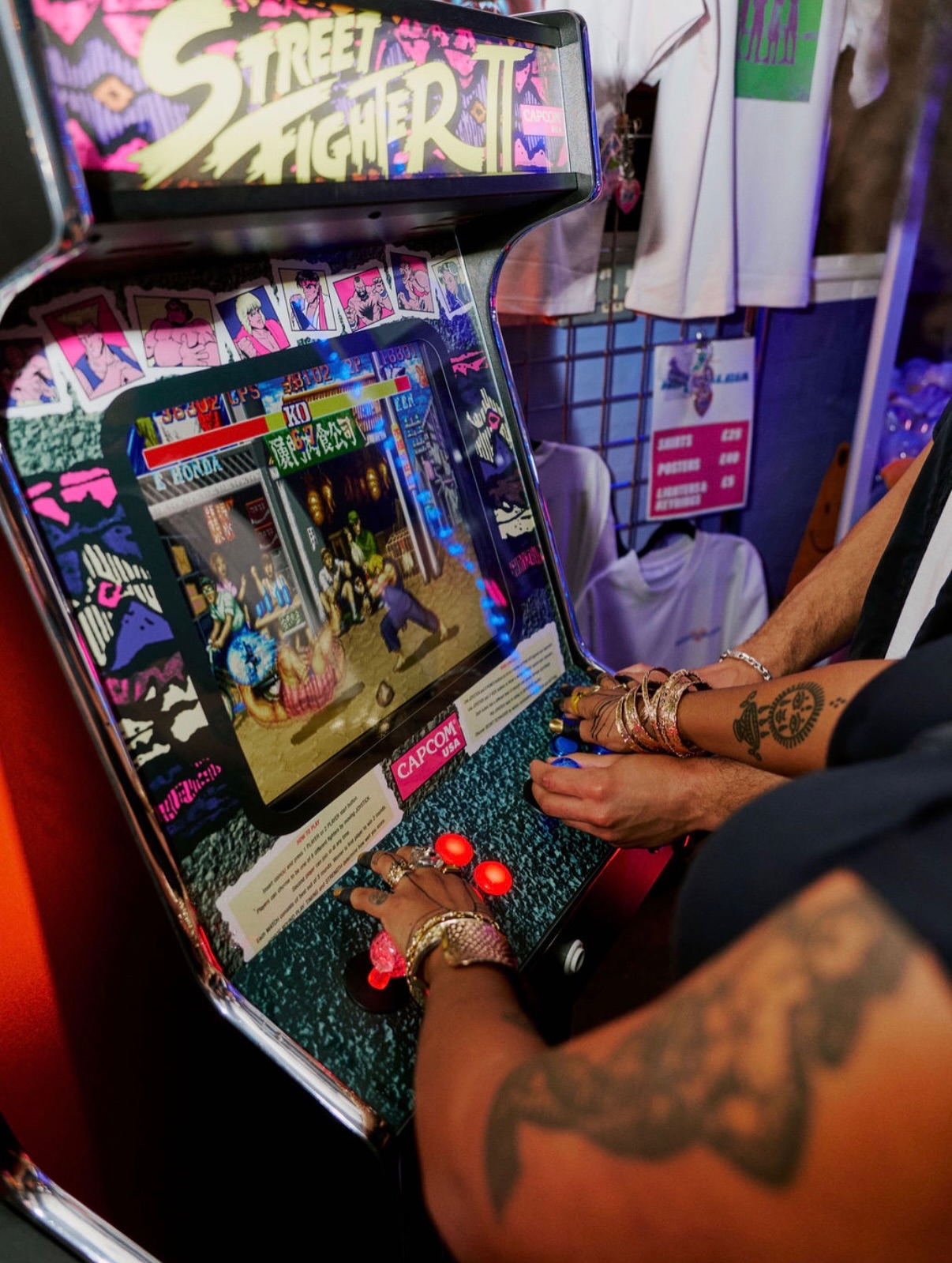 A neon-lit games room with classic arcade cabinets and racing games.