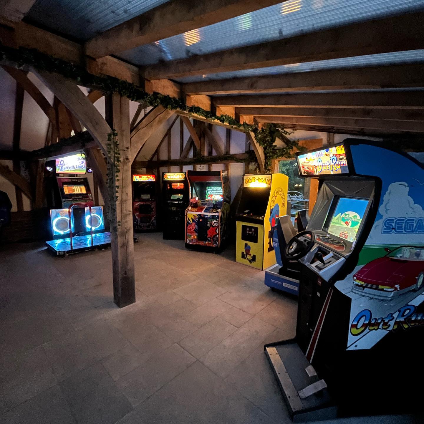 A collection of arcade machines set up in a timber-framed event venue.